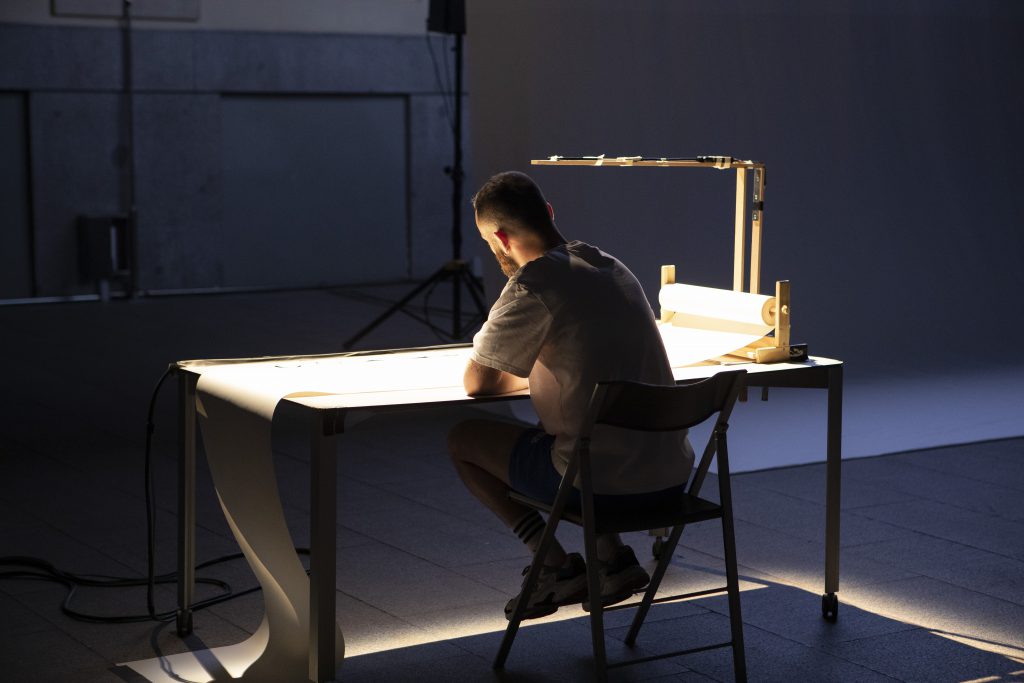 Óscar Bueno sitting and writting a music score live