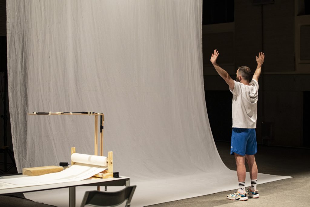 Óscar Bueno dancing in front of a long white sheet